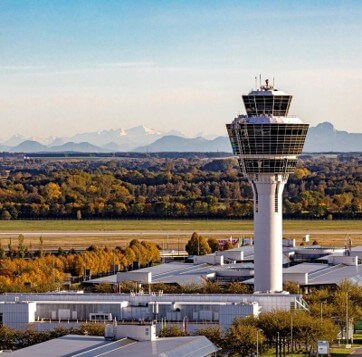 Ansicht des Towers des Flughafens München, im Hintergrund die Alpen